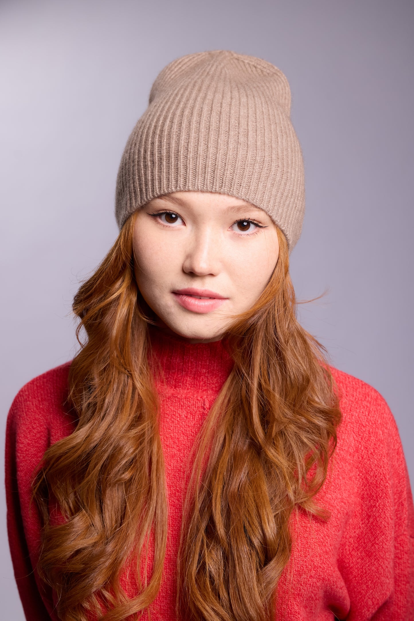 The cashmere hat features a snug fit with a vertically ribbed texture, providing a stylish yet minimalist design. The clean silhouette and classic ribbing make it a versatile accessory suitable for various casual or semi-formal outfits.