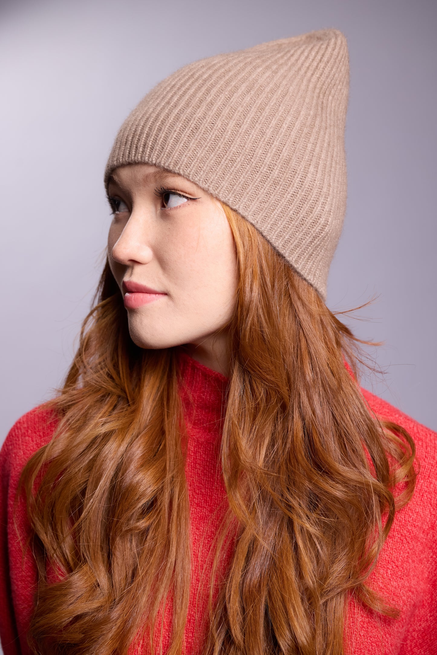 The cashmere hat features a snug fit with a vertically ribbed texture, providing a stylish yet minimalist design. The clean silhouette and classic ribbing make it a versatile accessory suitable for various casual or semi-formal outfits.