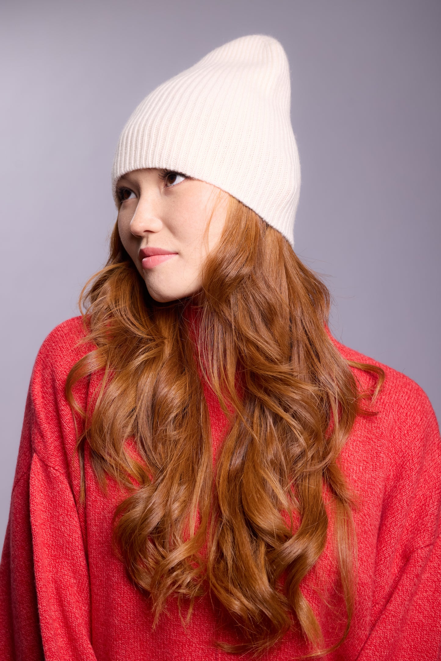 The cashmere hat features a snug fit with a vertically ribbed texture, providing a stylish yet minimalist design. The clean silhouette and classic ribbing make it a versatile accessory suitable for various casual or semi-formal outfits.