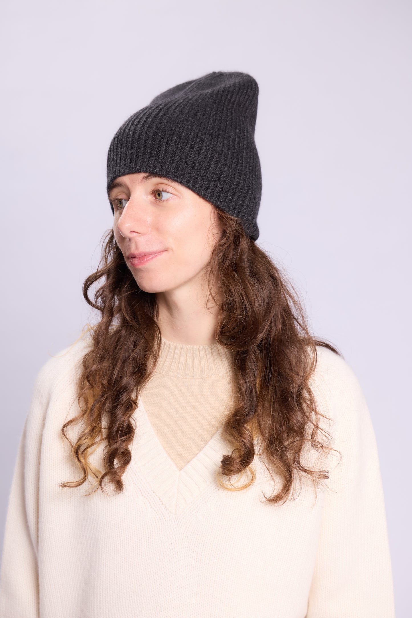 The cashmere hat features a snug fit with a vertically ribbed texture, providing a stylish yet minimalist design. The clean silhouette and classic ribbing make it a versatile accessory suitable for various casual or semi-formal outfits.