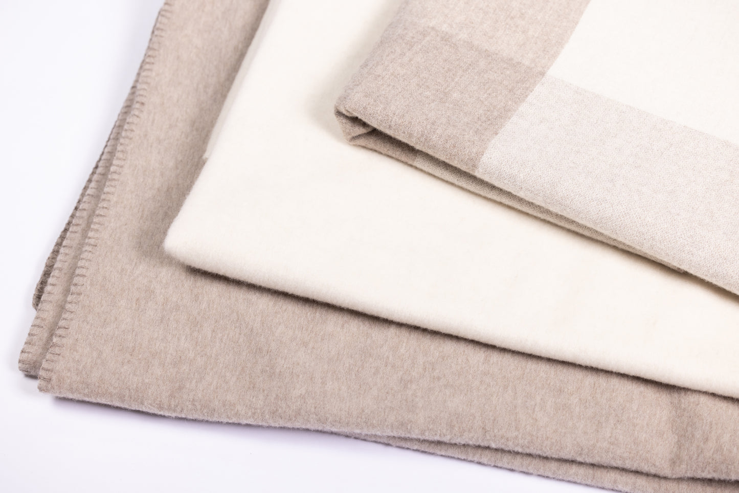 This 100% sheep wool blanket exudes warmth and natural elegance. The blanket is a soft, neutral beige and white, giving it a versatile and earthy look that can easily complement various home decors.