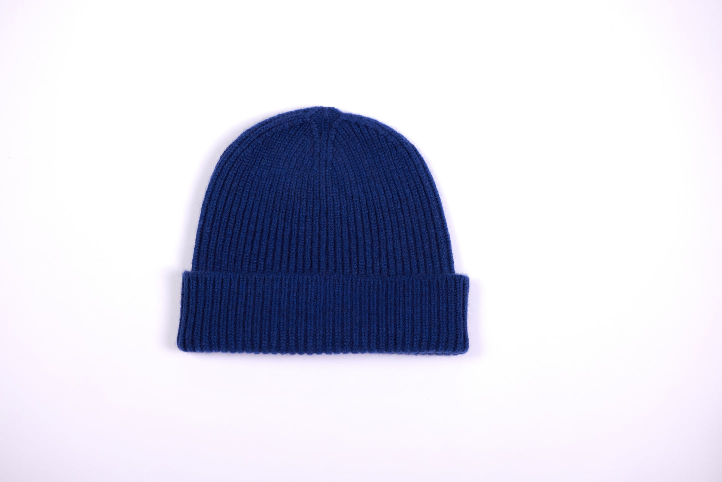 The cashmere hat features a snug fit with a vertically ribbed texture, providing a stylish yet minimalist design. The clean silhouette and classic ribbing make it a versatile accessory suitable for various casual or semi-formal outfits.