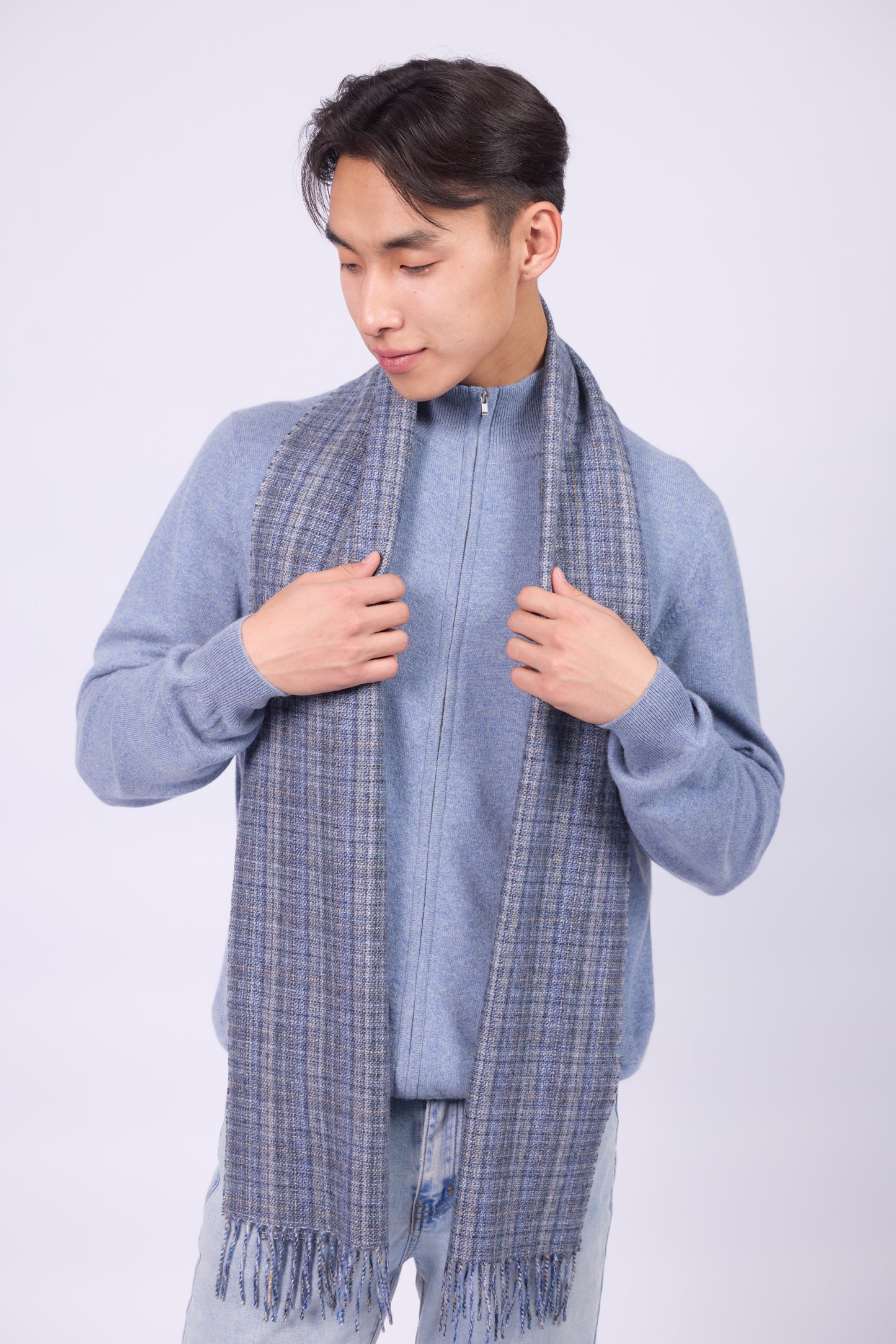 This scarf is a unisex 100% cashmere woven scarf, featuring a classic plaid pattern with a mix of pink, purple, and gray tones.