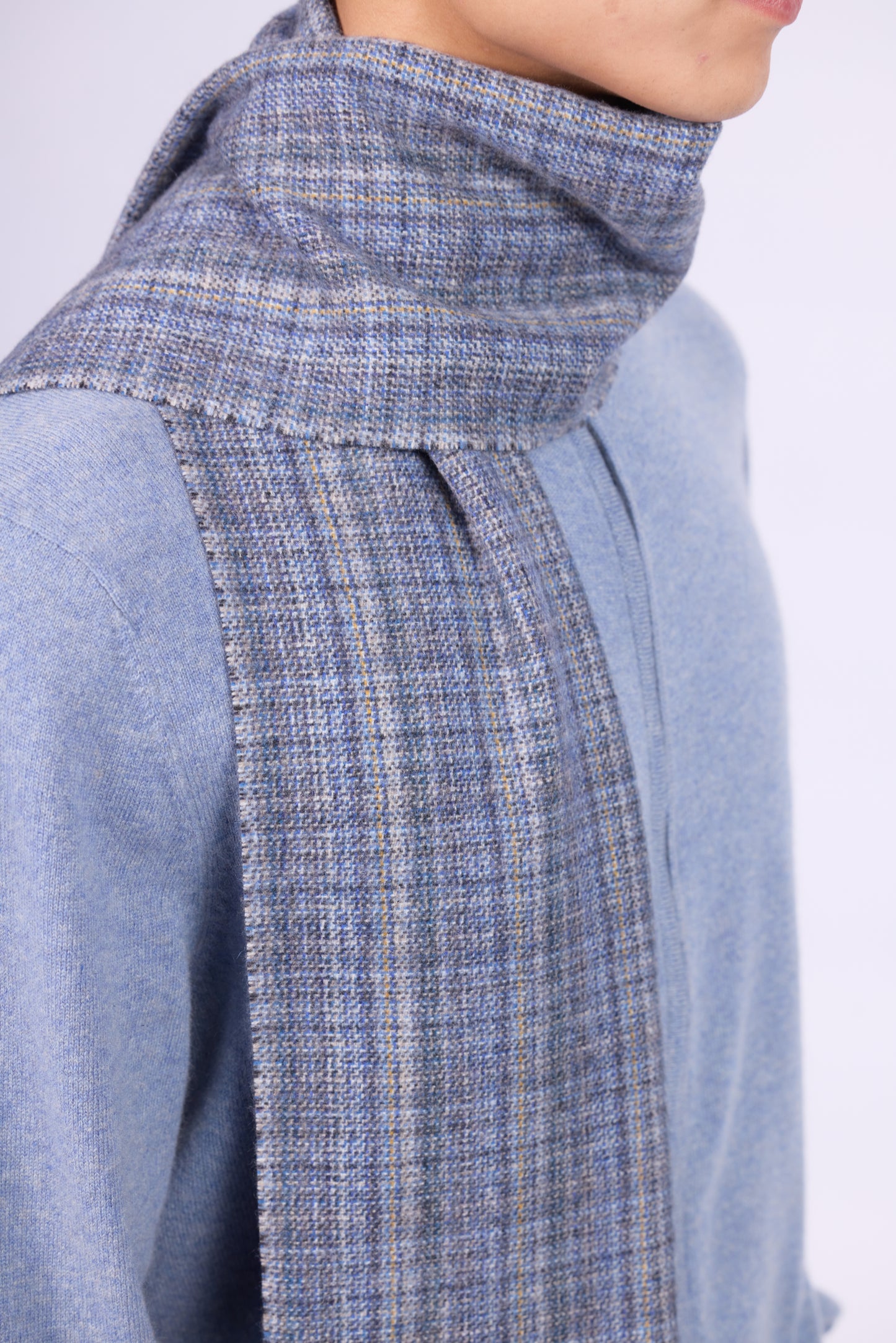 This scarf is a unisex 100% cashmere woven scarf, featuring a classic plaid pattern with a mix of pink, purple, and gray tones.