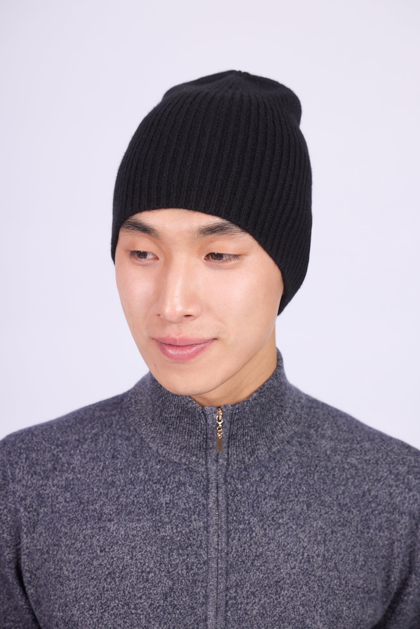 The cashmere hat features a snug fit with a vertically ribbed texture, providing a stylish yet minimalist design. The clean silhouette and classic ribbing make it a versatile accessory suitable for various casual or semi-formal outfits.