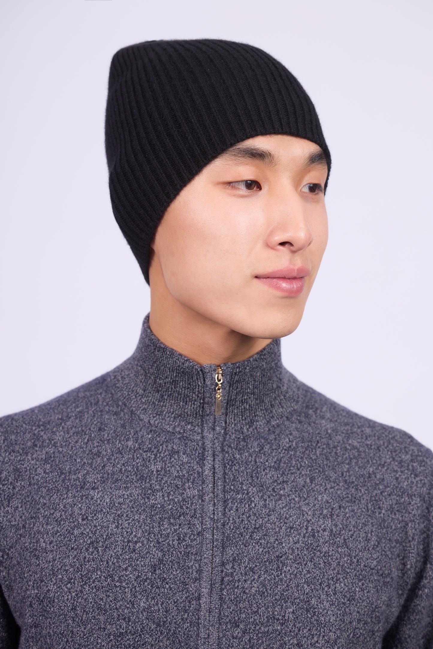The cashmere hat features a snug fit with a vertically ribbed texture, providing a stylish yet minimalist design. The clean silhouette and classic ribbing make it a versatile accessory suitable for various casual or semi-formal outfits.