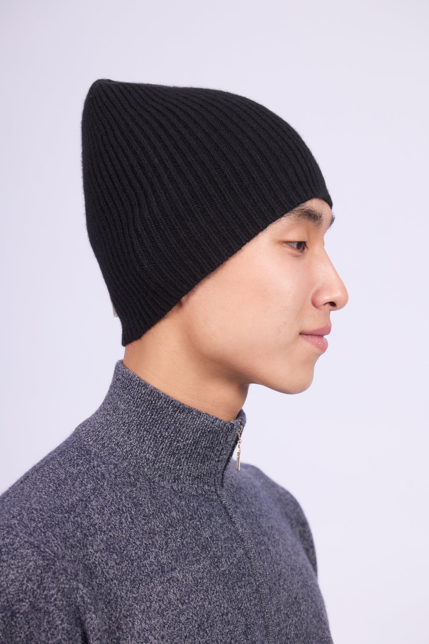 The cashmere hat features a snug fit with a vertically ribbed texture, providing a stylish yet minimalist design. The clean silhouette and classic ribbing make it a versatile accessory suitable for various casual or semi-formal outfits.