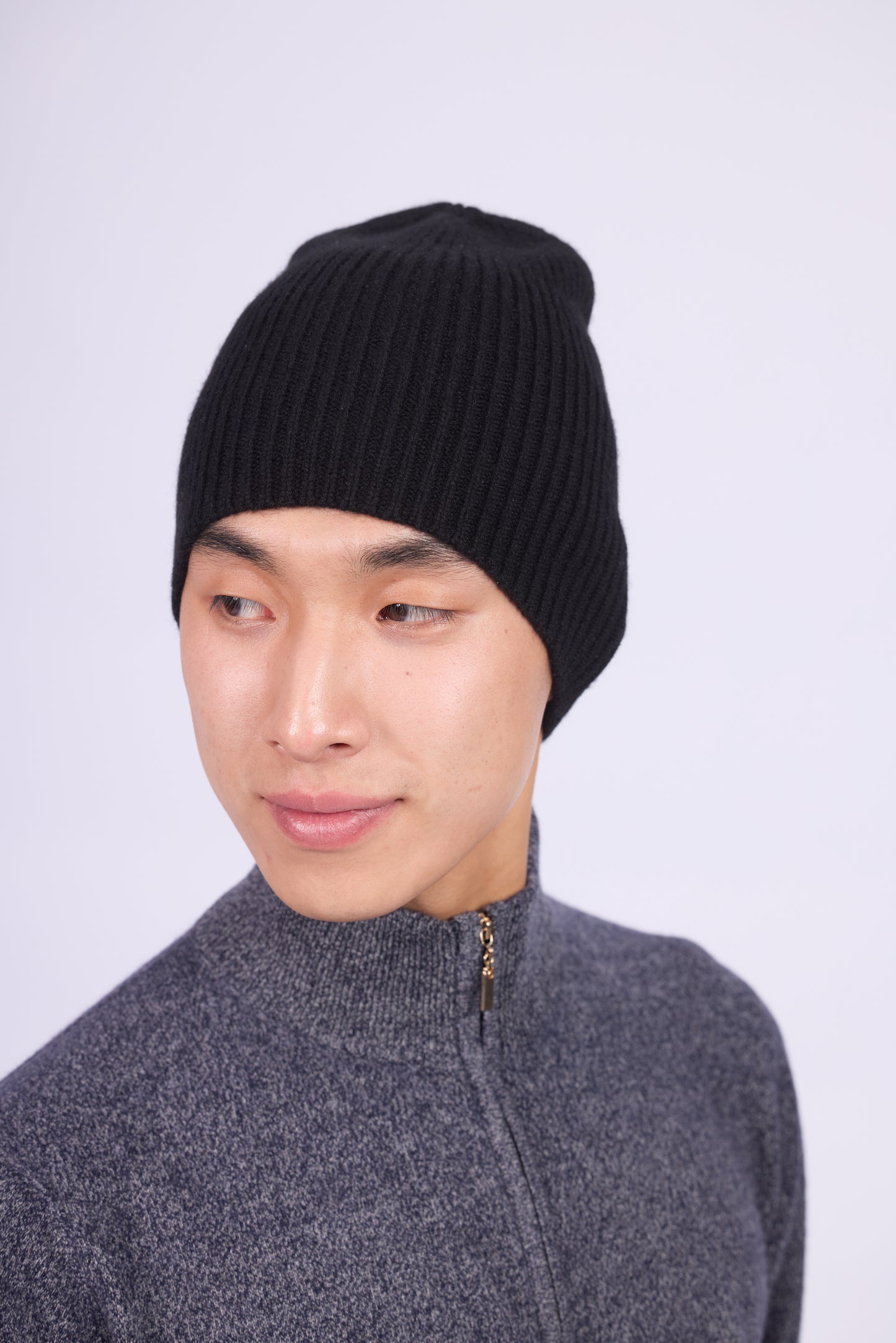 The cashmere hat features a snug fit with a vertically ribbed texture, providing a stylish yet minimalist design. The clean silhouette and classic ribbing make it a versatile accessory suitable for various casual or semi-formal outfits.