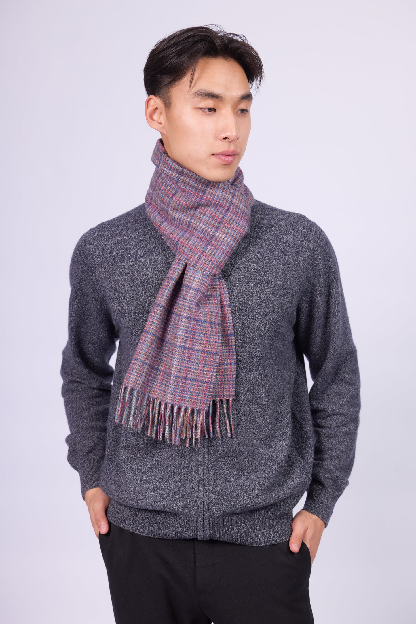 This scarf is a unisex 100% cashmere woven scarf, featuring a classic plaid pattern with a mix of pink, purple, and gray tones.