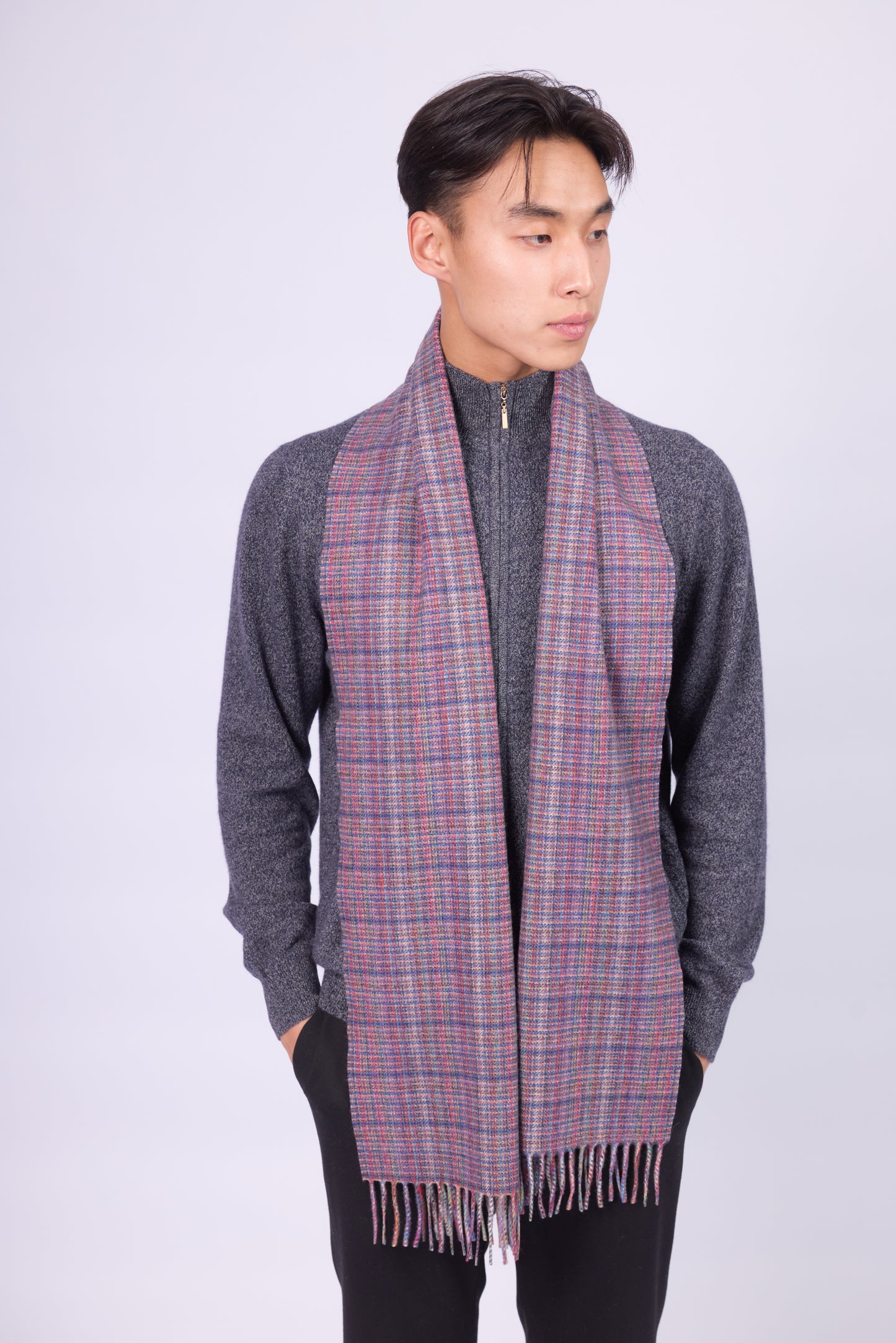 This scarf is a unisex 100% cashmere woven scarf, featuring a classic plaid pattern with a mix of pink, purple, and gray tones.