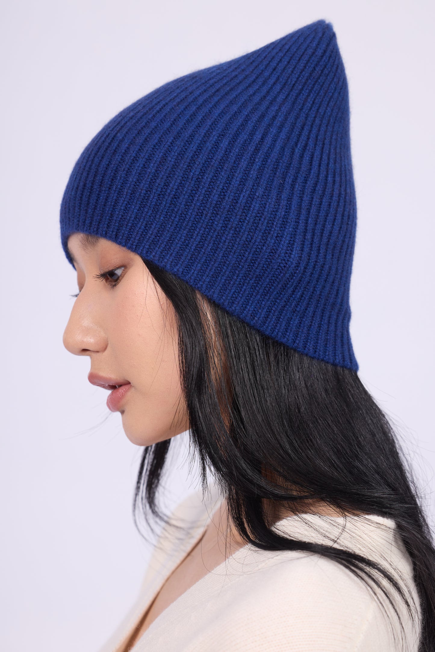 The cashmere hat features a snug fit with a vertically ribbed texture, providing a stylish yet minimalist design. The clean silhouette and classic ribbing make it a versatile accessory suitable for various casual or semi-formal outfits.