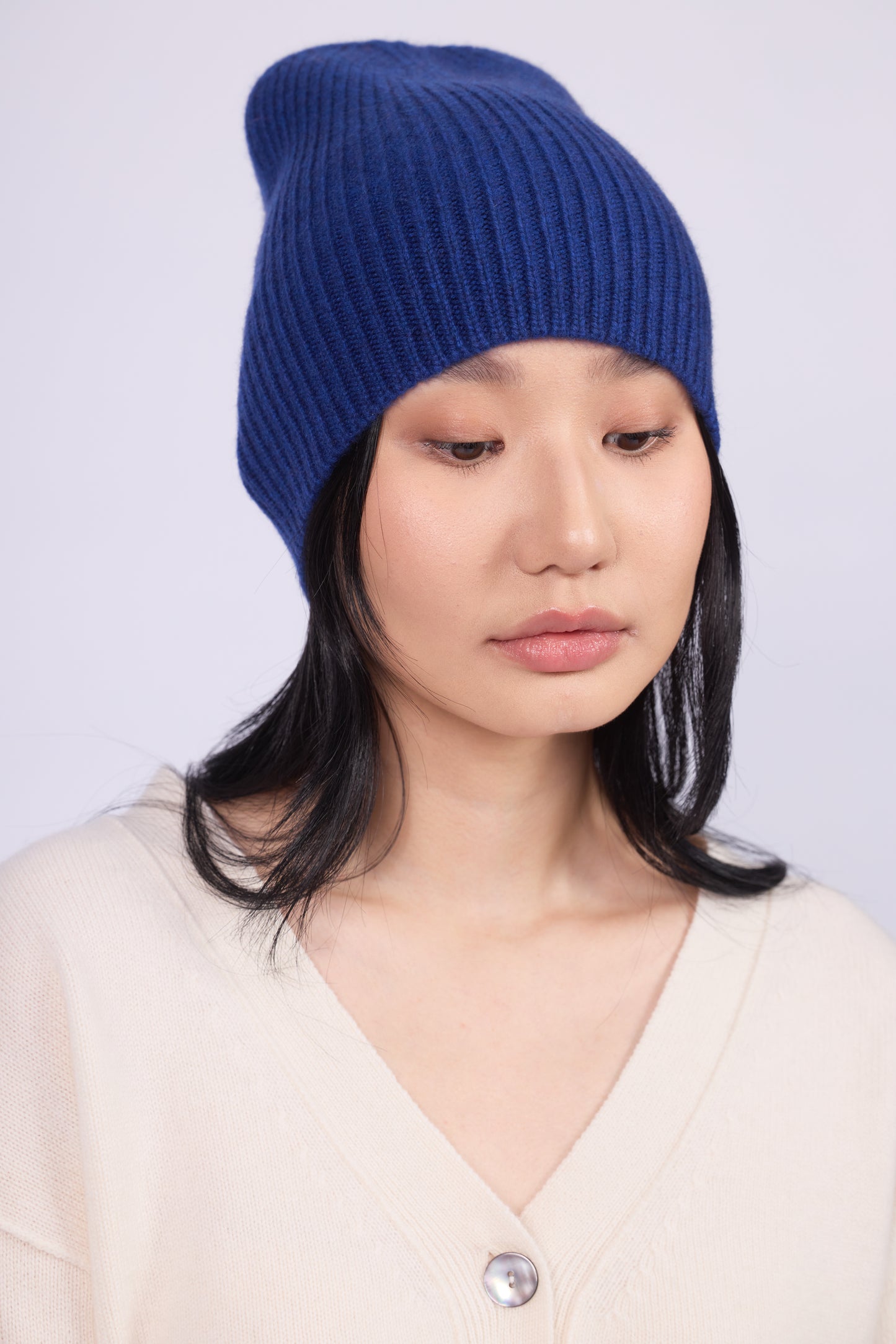The cashmere hat features a snug fit with a vertically ribbed texture, providing a stylish yet minimalist design. The clean silhouette and classic ribbing make it a versatile accessory suitable for various casual or semi-formal outfits.