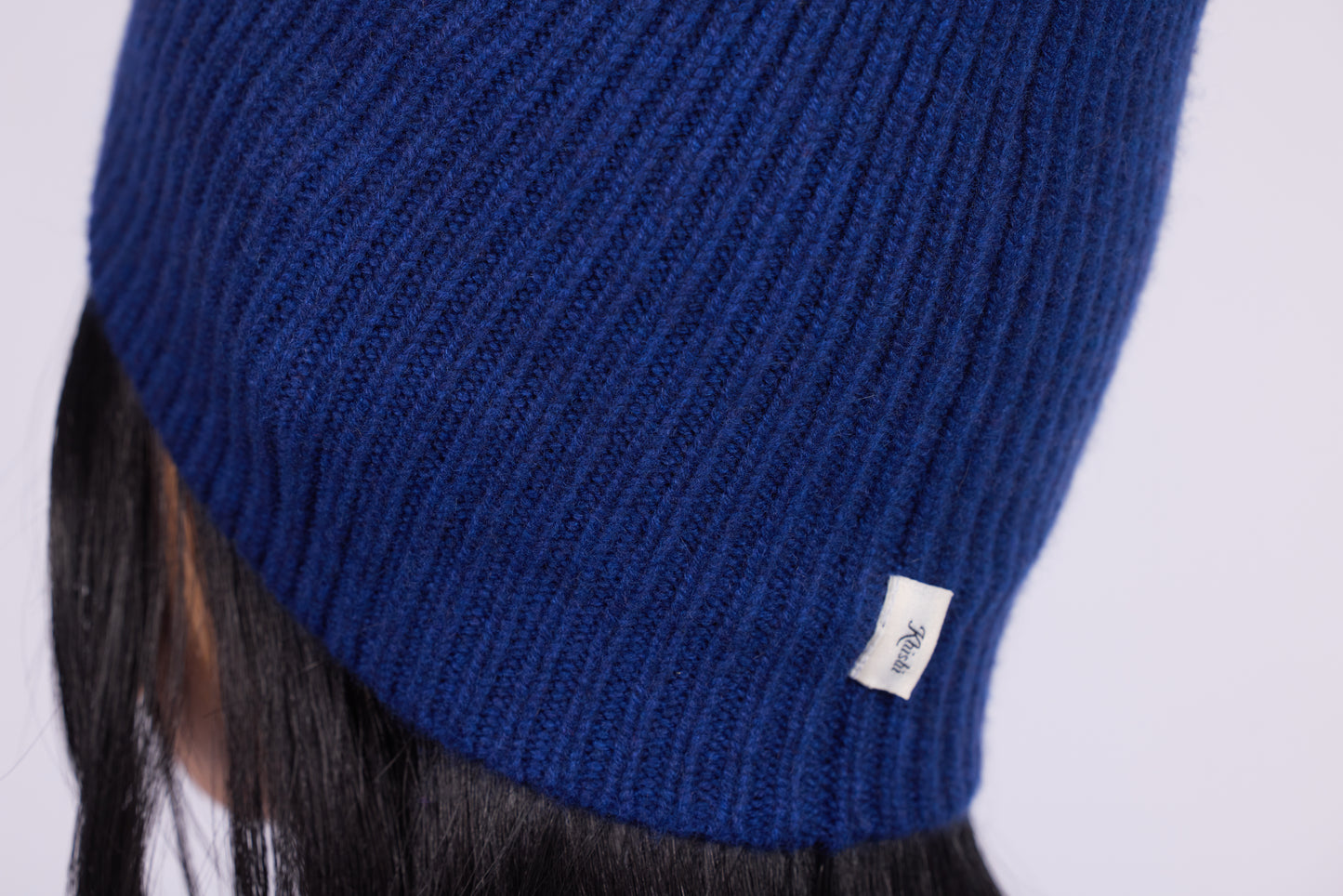 The cashmere hat features a snug fit with a vertically ribbed texture, providing a stylish yet minimalist design. The clean silhouette and classic ribbing make it a versatile accessory suitable for various casual or semi-formal outfits.
