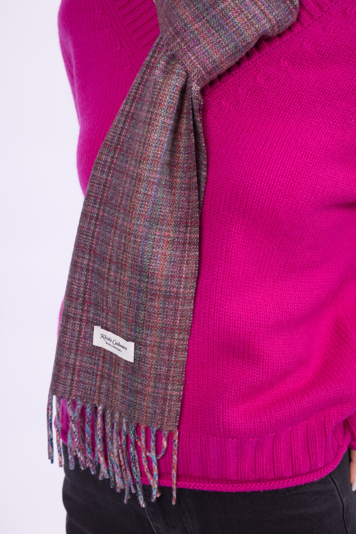This scarf is a unisex 100% cashmere woven scarf, featuring a classic plaid pattern with a mix of pink, purple, and gray tones.