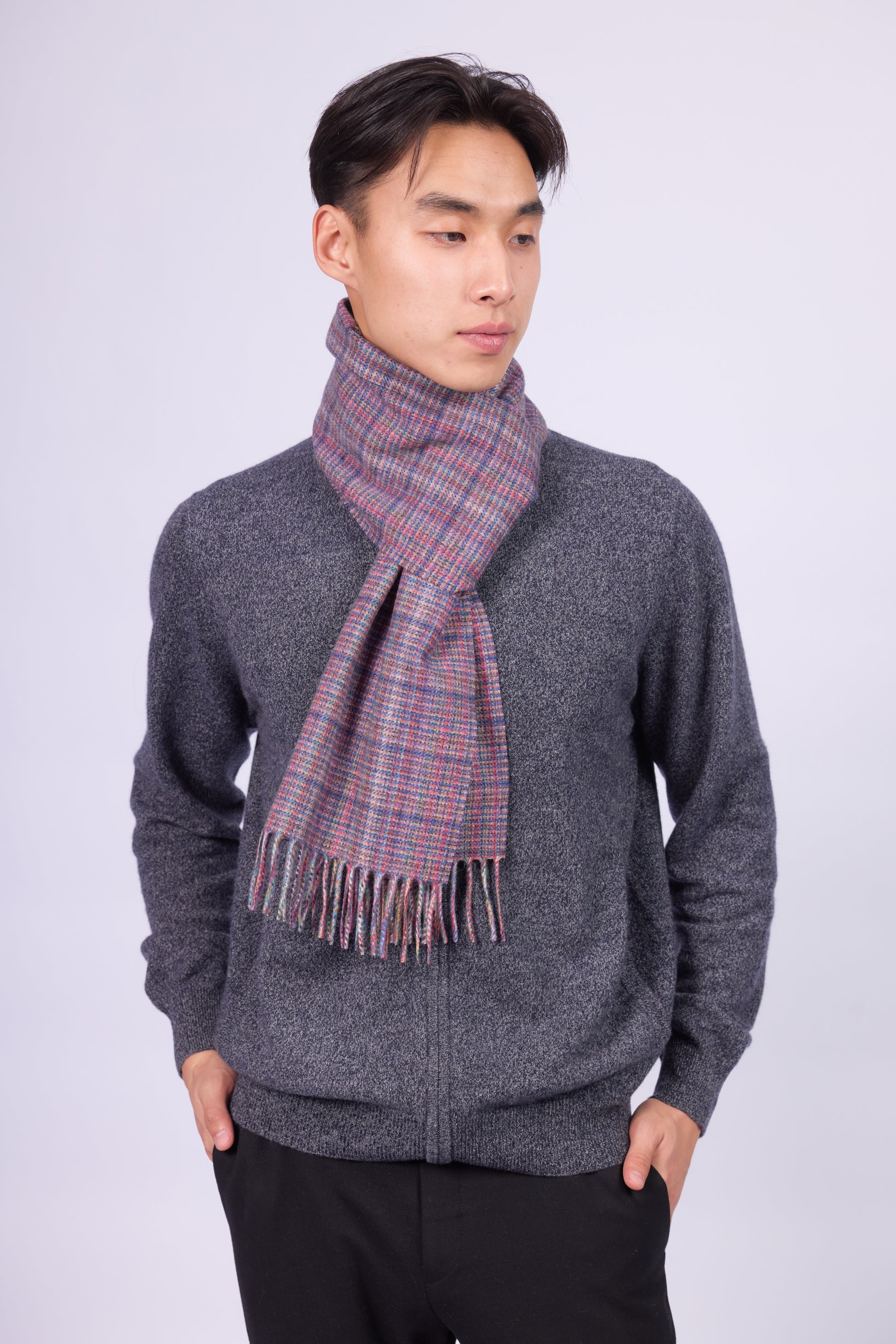 This scarf is a unisex 100% cashmere woven scarf, featuring a classic plaid pattern with a mix of pink, purple, and gray tones. 