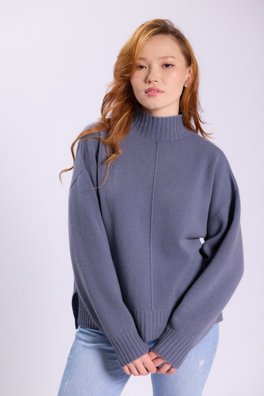 This cashmere sweater with a relaxed, oversized fit. It features a high mock neck, dropped shoulders, and long sleeves for a cozy appearance.
